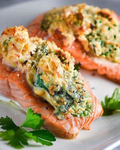 Shrimp stuffed salmon in air fryer with creamy herb filling, golden-brown topping, and fresh parsley.