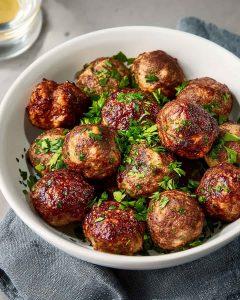 Air fryer italian meatballs with juicy, golden brown meatballs garnished with fresh parsley and a rich, savory glaze.